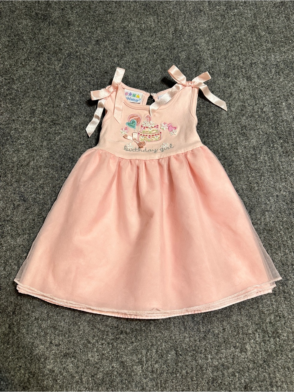 This is a light pink toddler "birthday girl" dress with a sheer tulle overlay